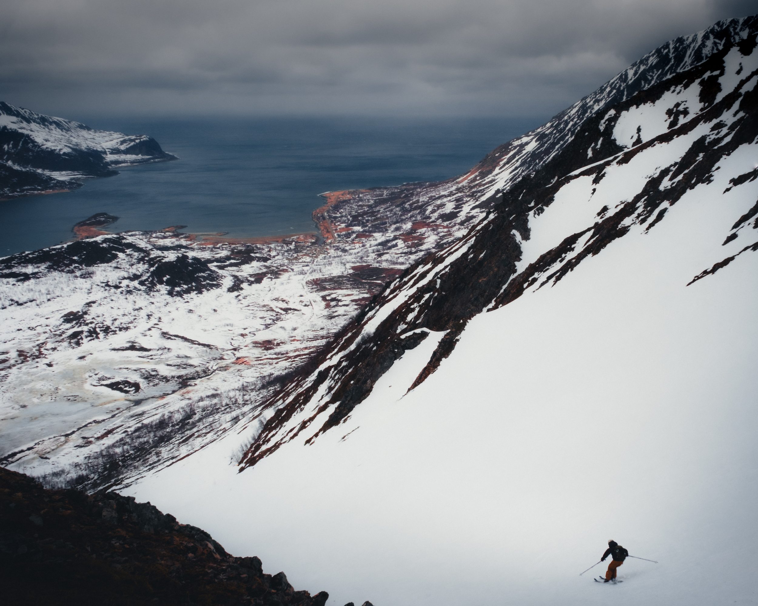 Fjord-village vantage, single skier