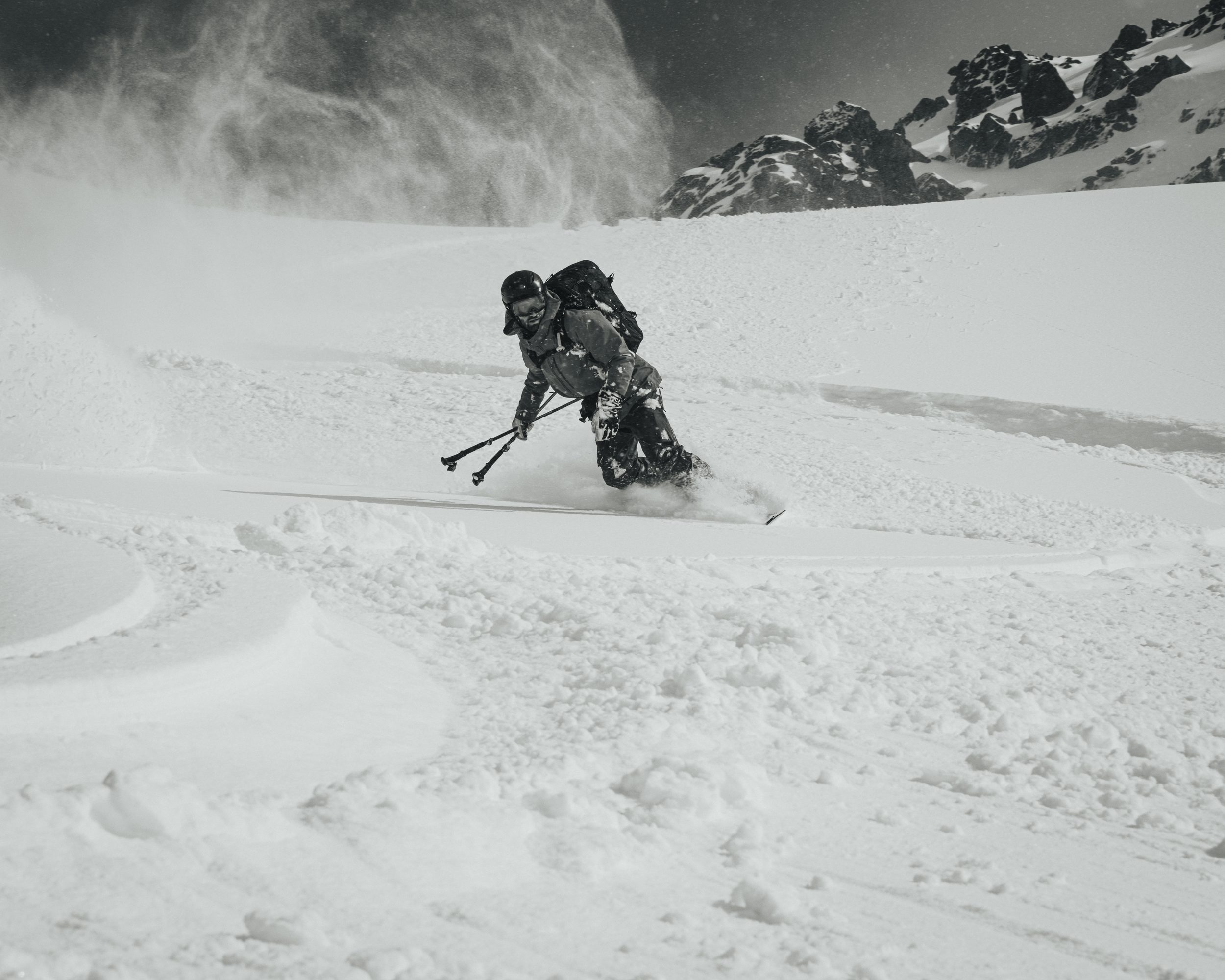 Backlit spindrift plume, dynamic rooster-tail in monochrome