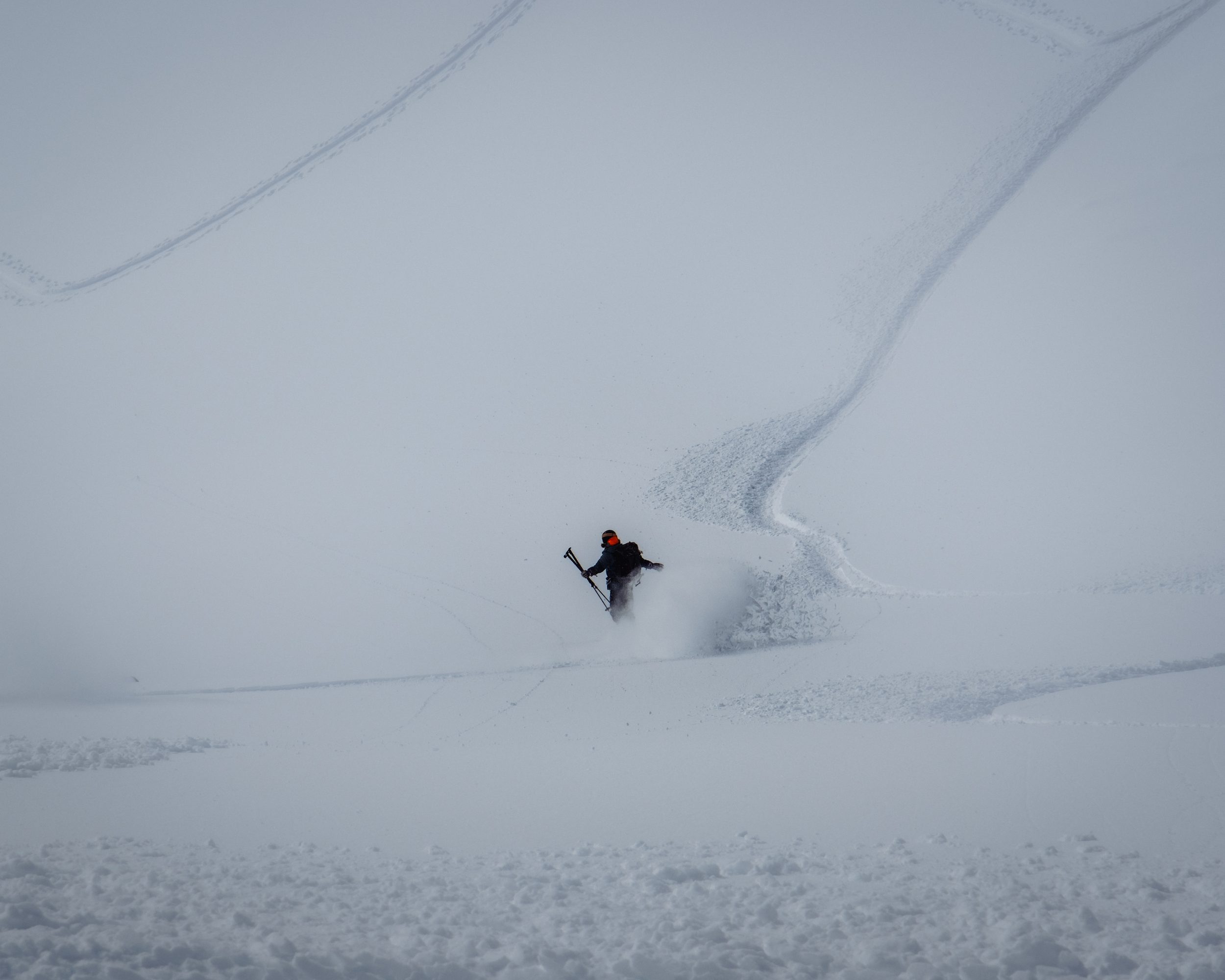 Lone skier carving across whiteout